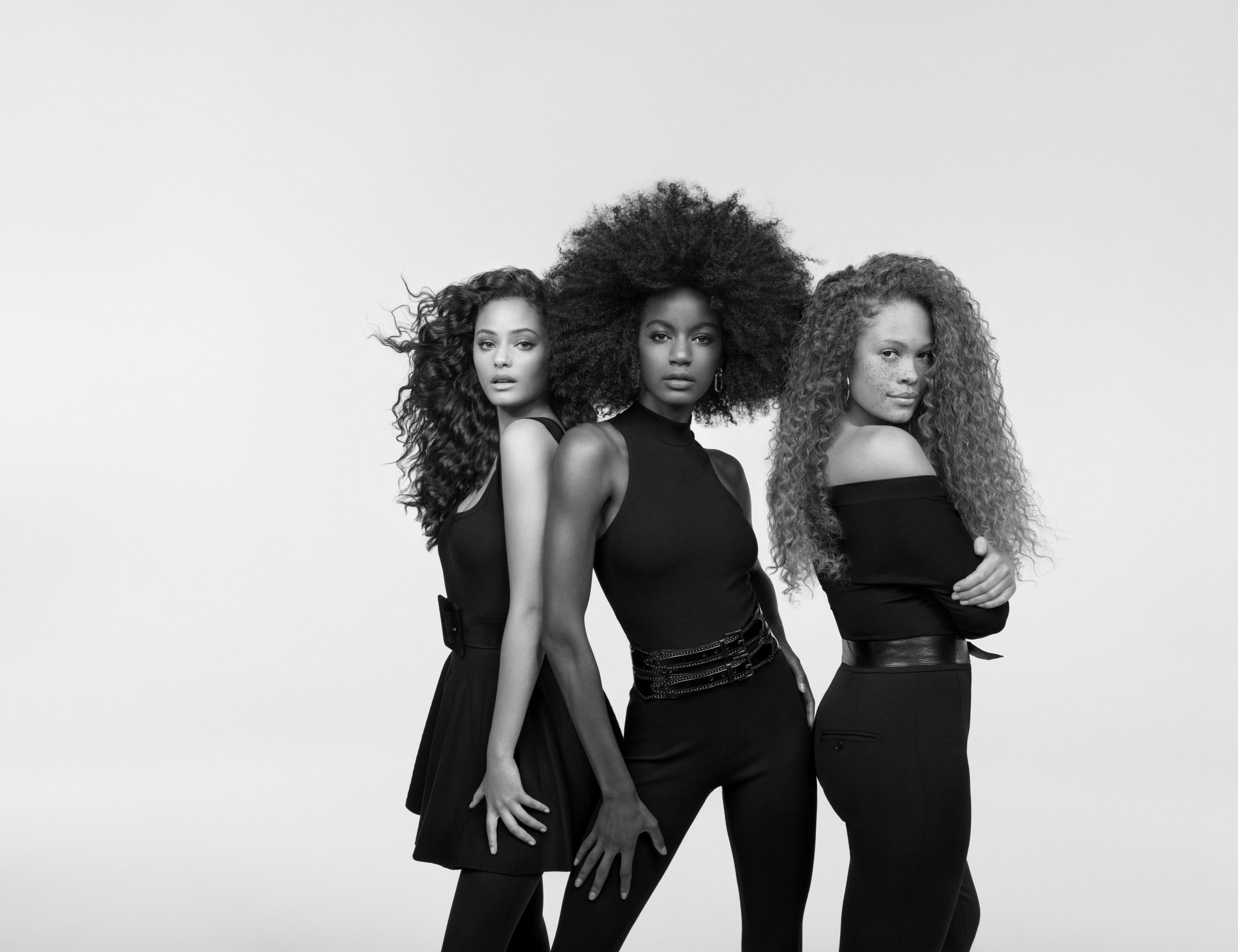 Trois femmes aux coiffures différentes illustrant la diversité des textures de cheveux